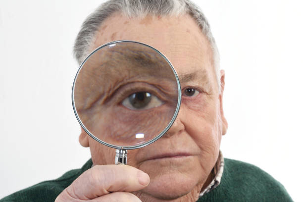 istock Senior man looking with a magnifying glass 898474650