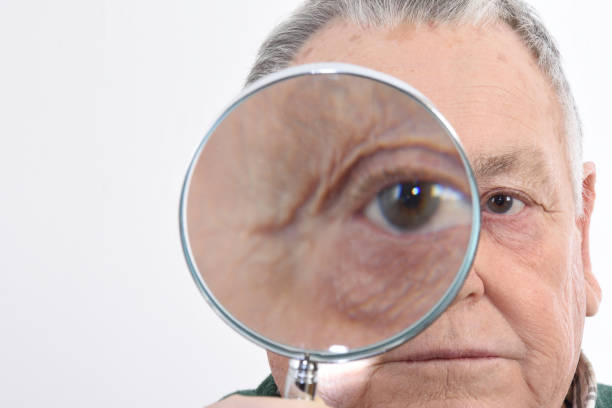 istock Senior man looking with a magnifying glass 898474662
