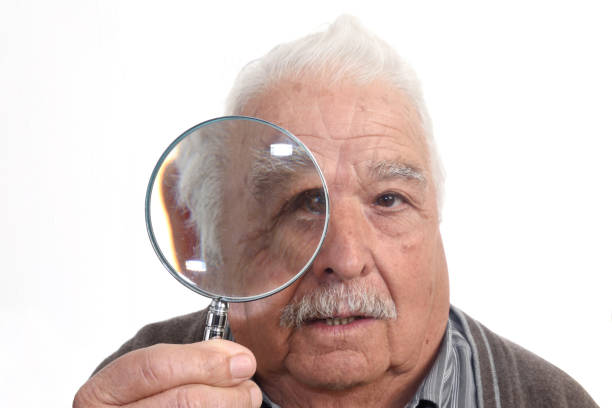 istock Curious man peering through magnifying glass 898474666