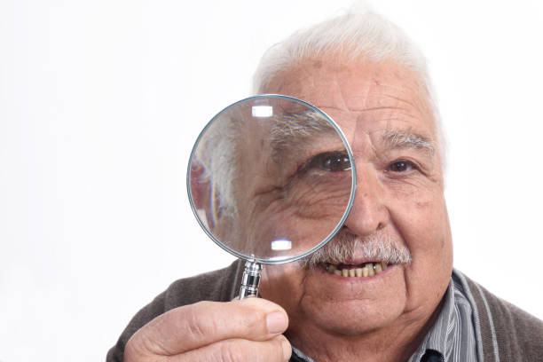istock Curious man peering through magnifying glass 898474668