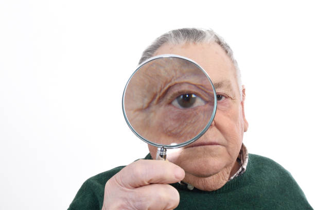 istock Senior man looking with a magnifying glass 898474674