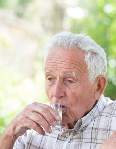 istock Portrait of senior man drinking short drink 898478774