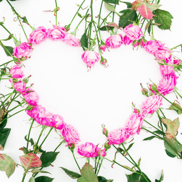 istock Heart made of pink roses on white background. Flat lay, top view. Valentine's background. Pattern made of flowers. 898482308