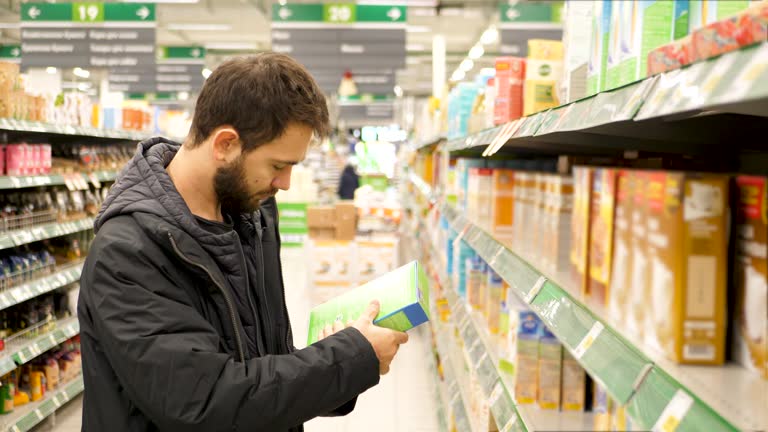 Man checking food labelling in supermarket. 4K UHD