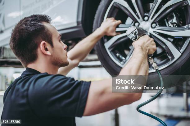 Handsome Auto Service Mechanics Stock Photo - Download Image Now - Tire - Vehicle Part, Mechanic, Car