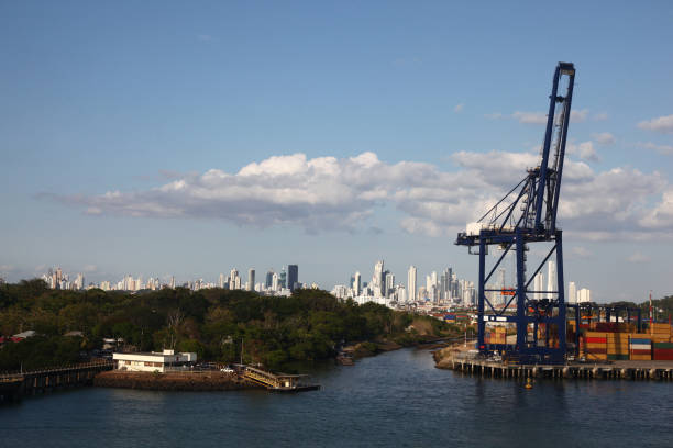 cargo port with crane & shipping containers along the entrance to the panama canal, with panama city in the background. - panama canal panama canal container imagens e fotografias de stock
