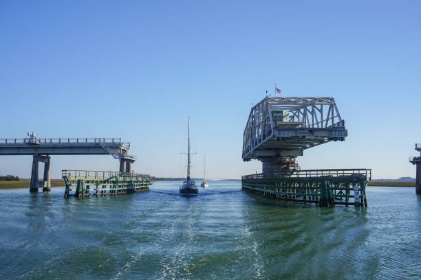 Atlantic Intracoastal Waterway, United States - two sailboats motor through an open highway swing bridge in Charleston, South Carolina