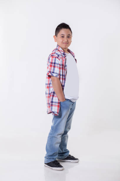 Casual portrait of a young boy smiling with hands in pockets Casual portrait of a young boy smiling with hands in pockets overweight boy stock pictures, royalty-free photos & images