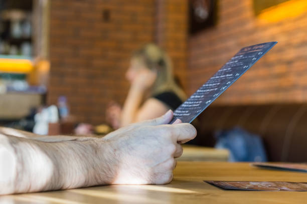 istock Close up a young man hands holding cafe menu for dinner. 898513152
