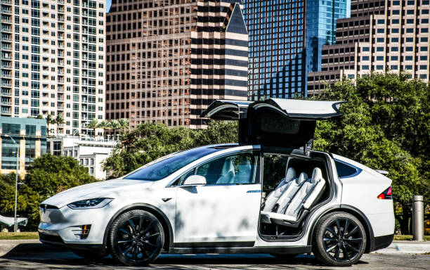 Tesla Model X in the Tech City of Austin, Texas, USA Urban Modern Future Electric Car. an Automotive masterpiece Austin, Texas, USA - December 12, 2017: Tesla Model X Futuristic Electric Cars Parked in Front of Austin Texas Downtown Skyline with falcon winged doors open and ready for a free clean ride of renewable energy powered by batteries. On a sunny day in the capital city with Tesla Owner showing off new Electric Smart Car. tesla model x stock pictures, royalty-free photos & images