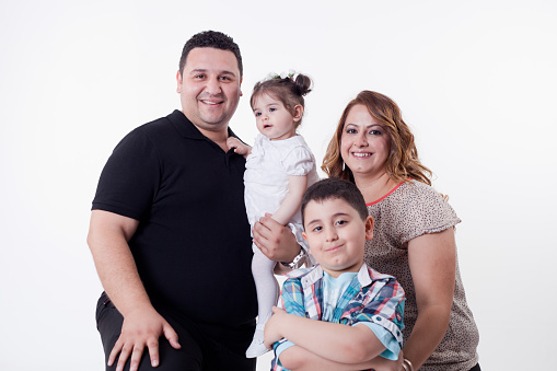 Mother and father with son  and  daughter studio shoot white background.