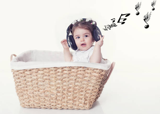 little girl in basket listen musıc over white background - new life one baby girl only beginnings babies only imagens e fotografias de stock