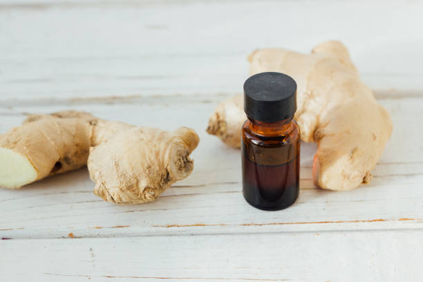 istock Ginger essential oil in glass bottle with ginger root behind. 898531296
