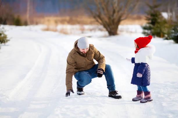 istock Father and daughter at snowy park. 898531392