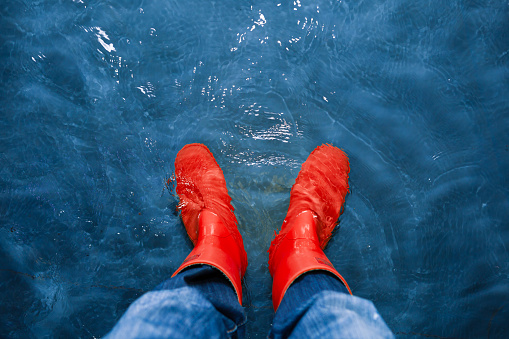 red rubber boots in the water, top view