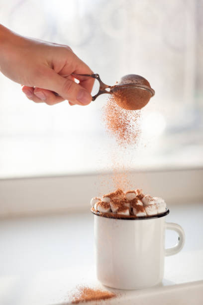 istock Hot cocoa in cup with mini marshmallows and hand sprinkles cocoa powder on window sill 898545740