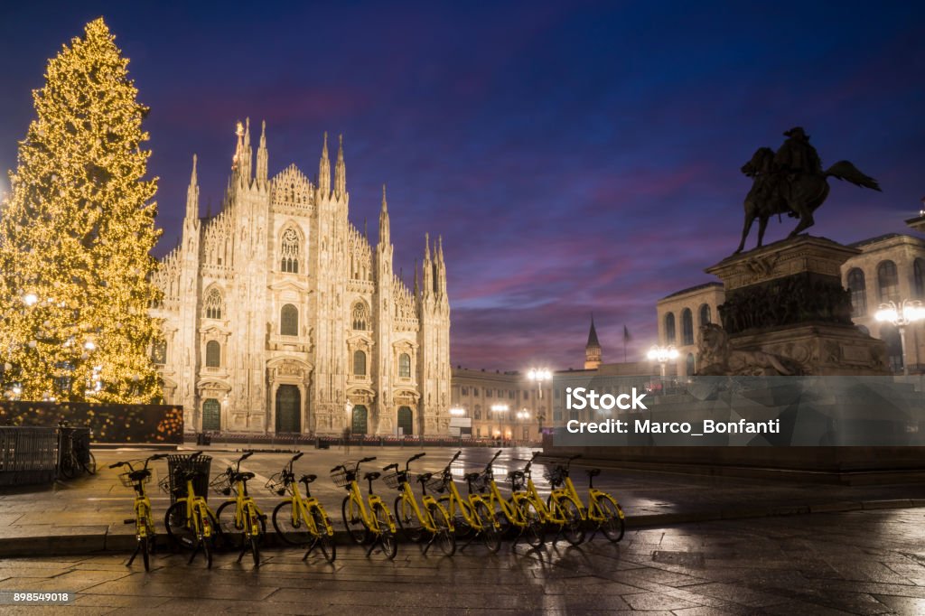 Milan, Italy: Duomo square in december Milan, Italy: Duomo square in december with the christmas tree in front of Milan cathedral, night view. A row of yellow sharing bicycles in the foreground. Bicycle Sharing System Stock Photo