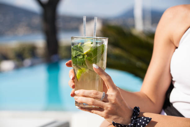 Woman holding glass of mojito in her hand. stock photo