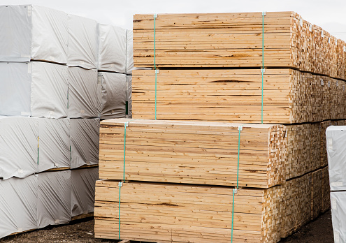 horizontal image of a pile of lumber stacked and tied together.