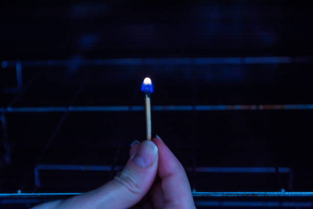 istock lighting match stick in front of the stove oven 898566446