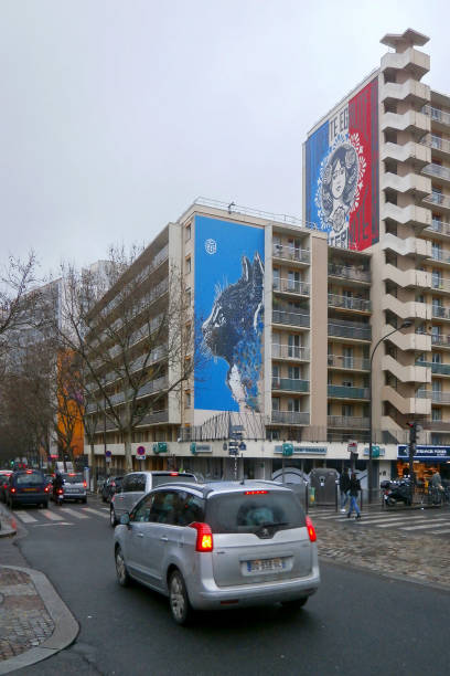 Paris, France - December 21 2017: Series of two murals, located on the Boulevard Vincent Auriol near the Chevaleret subway in the 13th arrondissement of Paris. The one on the top entitled « Liberté, Égalité, Fraternité » from Shepard Fairy and the other one « The cat » from C215.