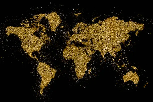 Photo of the world shaped from golden glitter on black (series)