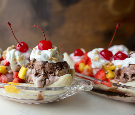 Banana splits with chocolate, vanilla and strawberry ice cream. Whipped cream topping with cherries.