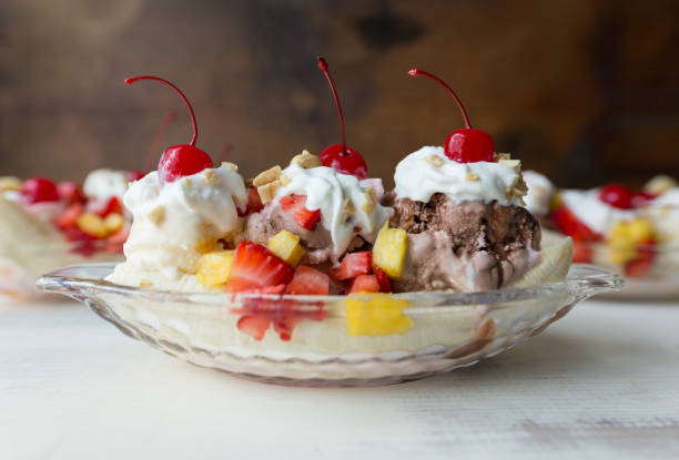 banana splits en botes de cristal con fresas, piña y cereza guarnición. - banana split fotografías e imágenes de stock