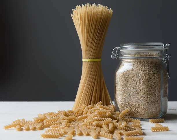 istock Brown rice pasta on gray background. Gluten free concept. Rotini, spaghetti, copy space. 898575518