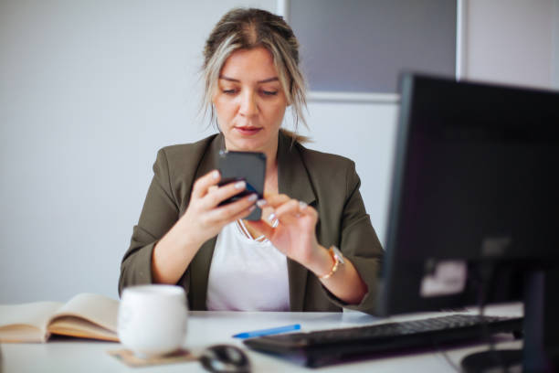 istock Young businesswoman using mobile phone at work 898581724