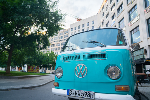 Blue VW Kombi van front with renown emblem parked in Berlin street.