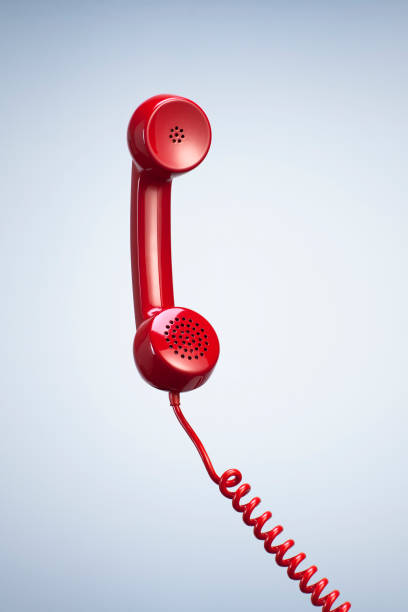 récepteur de téléphone rouge avec câble suspendu isolé beau fond de studio. - phone cord photos photos et images de collection