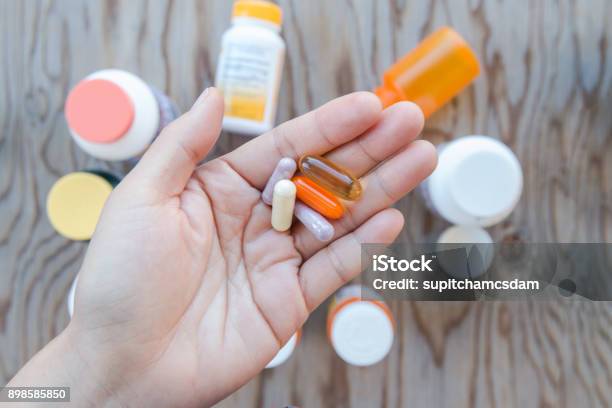 A Hand Holding A Bunch Of Pills In An Open Palm Stock Photo - Download Image Now - Medicine, Nutritional Supplement, Vitamin