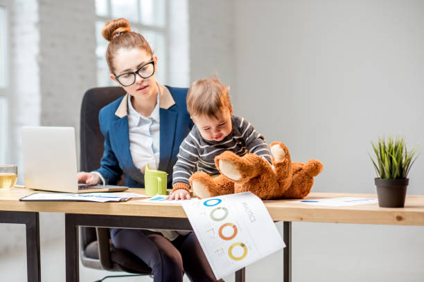 istock Multitasking businesswoman with her son working at the office 898586094