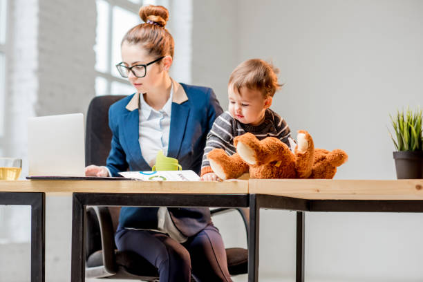 istock Multitasking businesswoman with her son working at the office 898586128