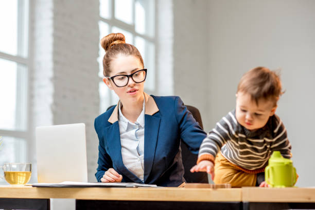 istock Multitasking businesswoman with her son working at the office 898586174
