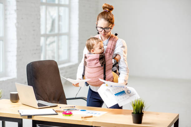 istock Businesswoman with her baby son working with documents at the office 898587008