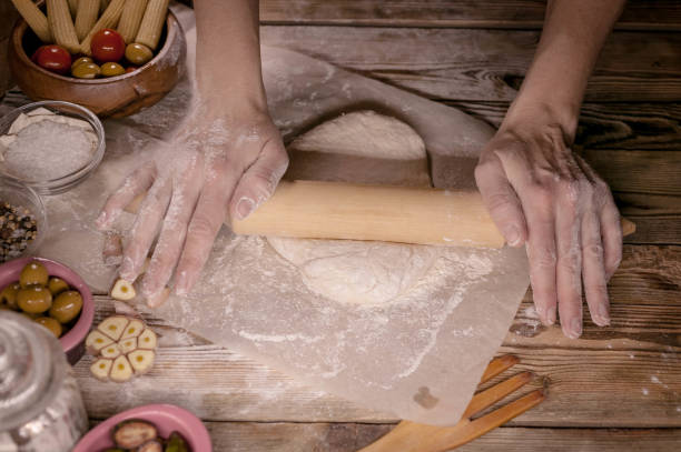 istock Female hands cook dough for home-made pizza. 898592958