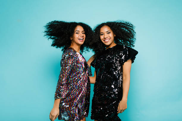 istock Two female friends having fun in studio with hair blowing 898596802