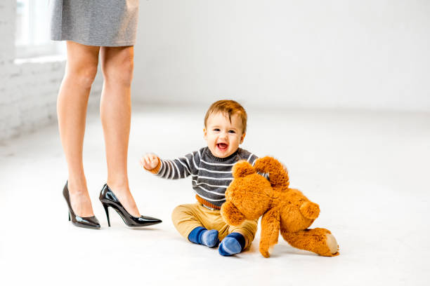 istock Baby boy near mother's legs 898597726