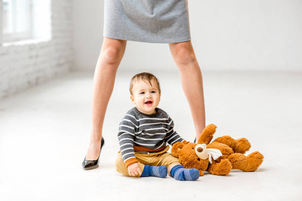 istock Baby boy near mother's legs 898597786