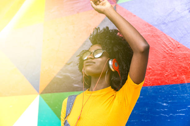 mujer africana bailando su canción favorita - musica popular fotografías e imágenes de stock