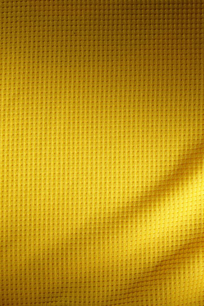 deporte ropa de fondo de textura de tela. vista superior de la superficie textil del paño. camiseta de fútbol amarilla. espacio de texto - laundry basket fotografías e imágenes de stock