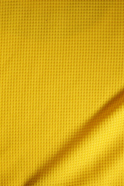 deporte ropa de fondo de textura de tela. vista superior de la superficie textil del paño. camiseta de fútbol amarilla. espacio de texto - laundry basket fotografías e imágenes de stock