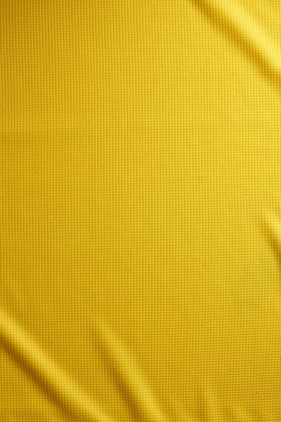 sport bekleidung stoff textilhintergrund. draufsicht der textiloberfläche tuch. gelbe fußballtrikot. text-raum - textilien stock-fotos und bilder