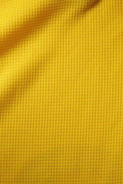 deporte ropa de fondo de textura de tela. vista superior de la superficie textil del paño. camiseta de fútbol amarilla. espacio de texto - laundry basket fotografías e imágenes de stock