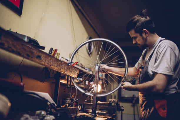 istock Young man repairing bicycle wheel 898607916