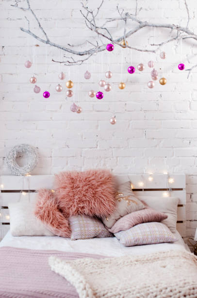 istock Bed with pink pillows and decorated a branch with christmas balls 898612108