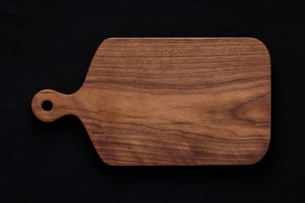 istock Walnut handmade wooden cutting board on black cotton 898619110