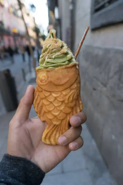 Enjoying a fish shapes Match Ice Cream cone with Carmel and White Chocolate Drizzle on the streets of Madrid, Spain.